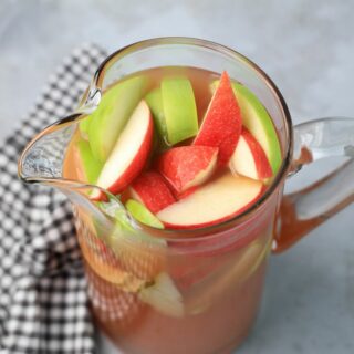 Punch in a glass pitcher with honey crisp apples and granny smith apples.