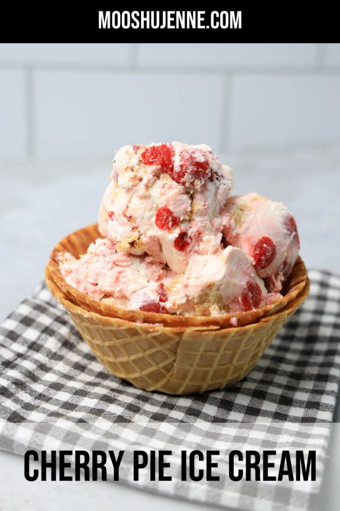 Cherry Pie Ice Cream in a waffle cone bowl with a gray plaid napkin on a faux concrete backdrop.