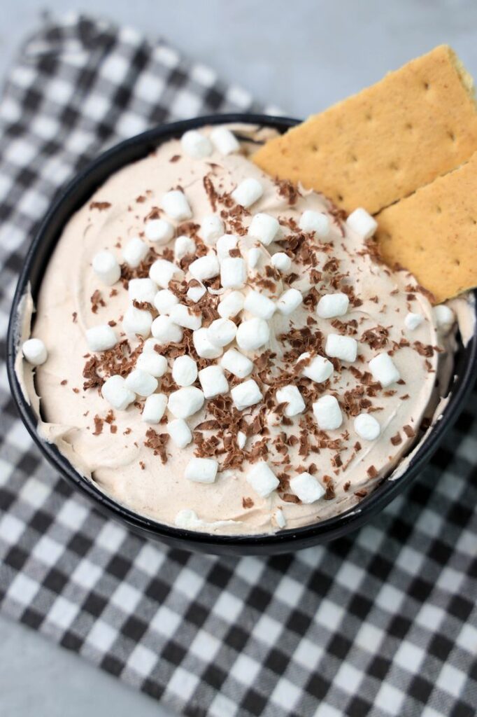 Hot Chocolate dip made with whipped topping and topped with marshmallow bits and chocolate curls.