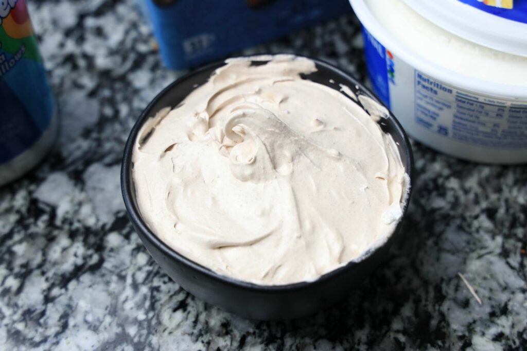 Marshmallow fluff, cool whip, and hot chocolate mix together in a bowl.