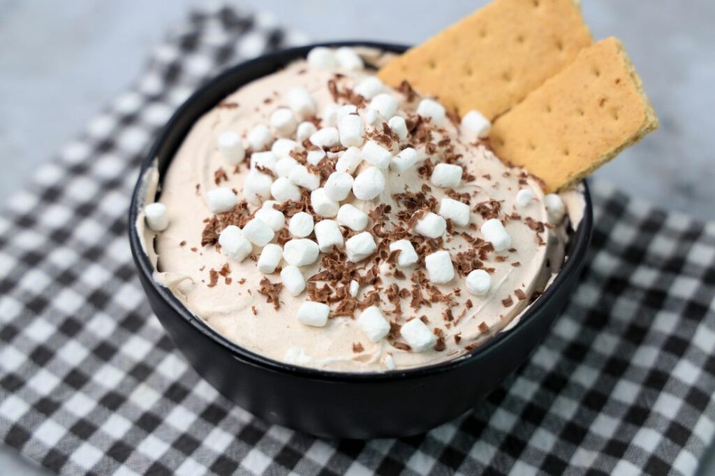 Hot Chocolate dip made with whipped topping and topped with marshmallow bits and chocolate curls.