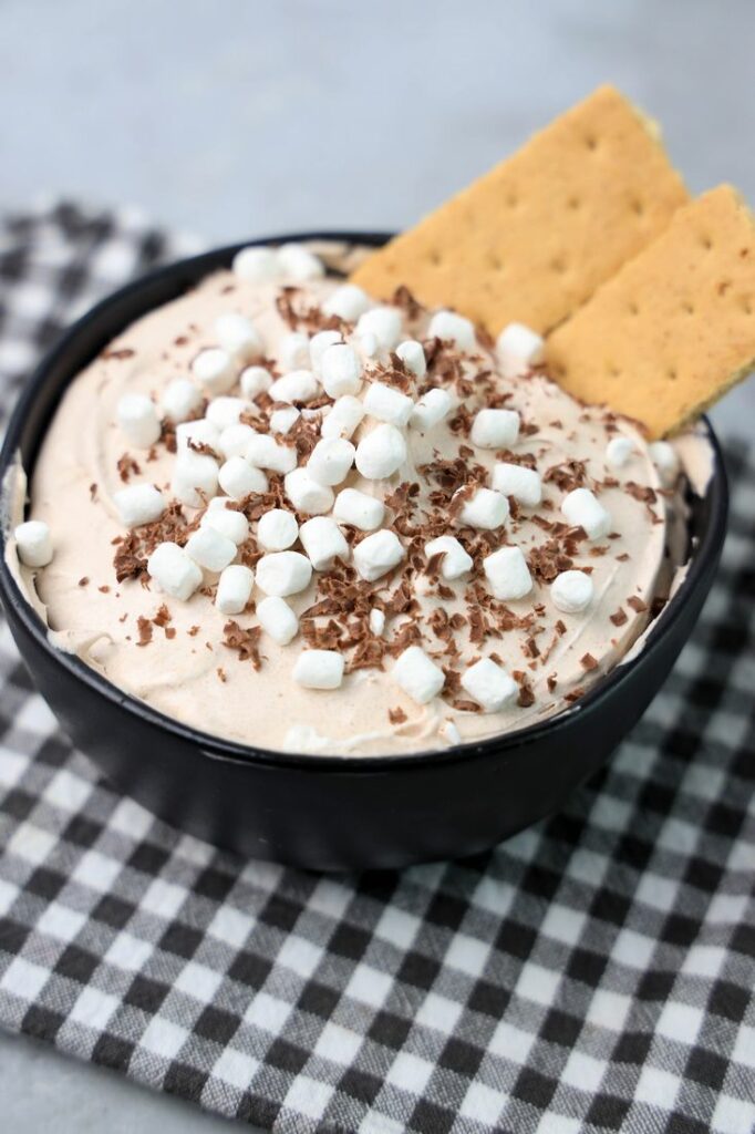 Hot Chocolate dip made with whipped topping and topped with marshmallow bits and chocolate curls.