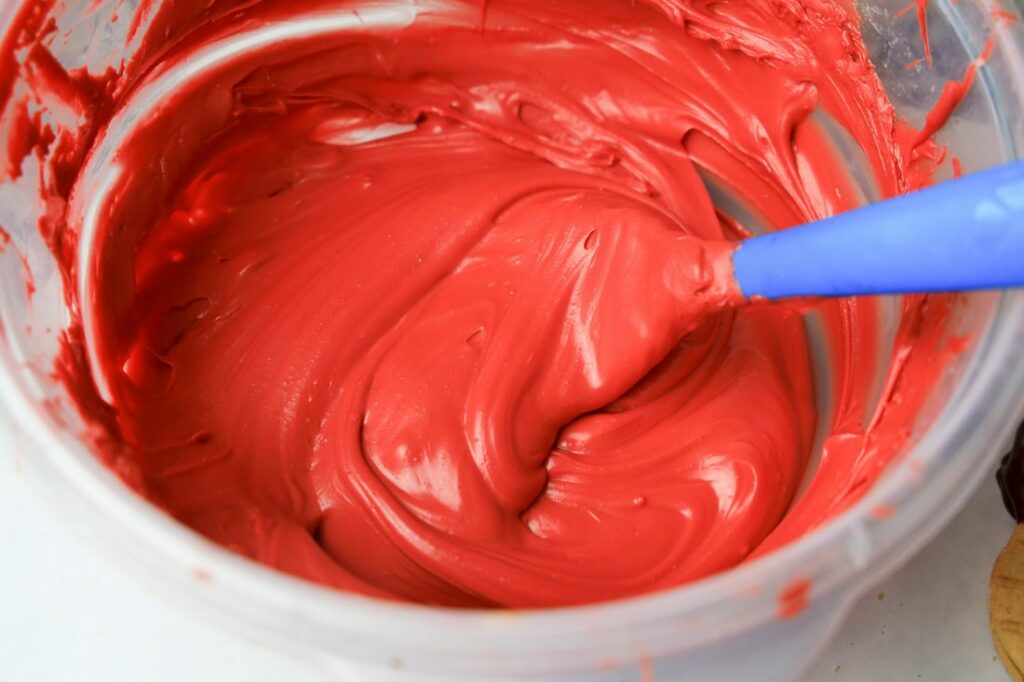 Red candy melts melted in a plastic bowl.