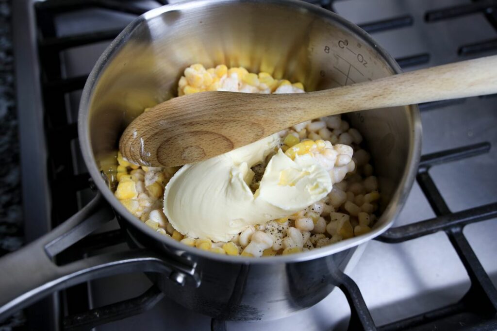 Corn, margarine, and heavy cream in a pot.