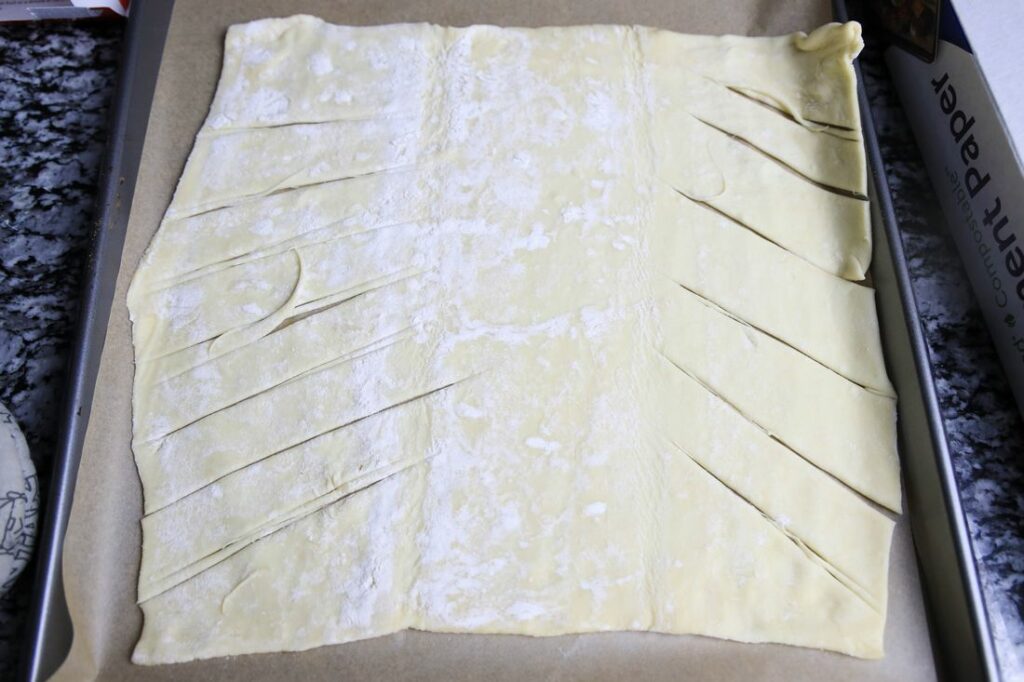 Puff pastry dough laid out with cuts for the braid.