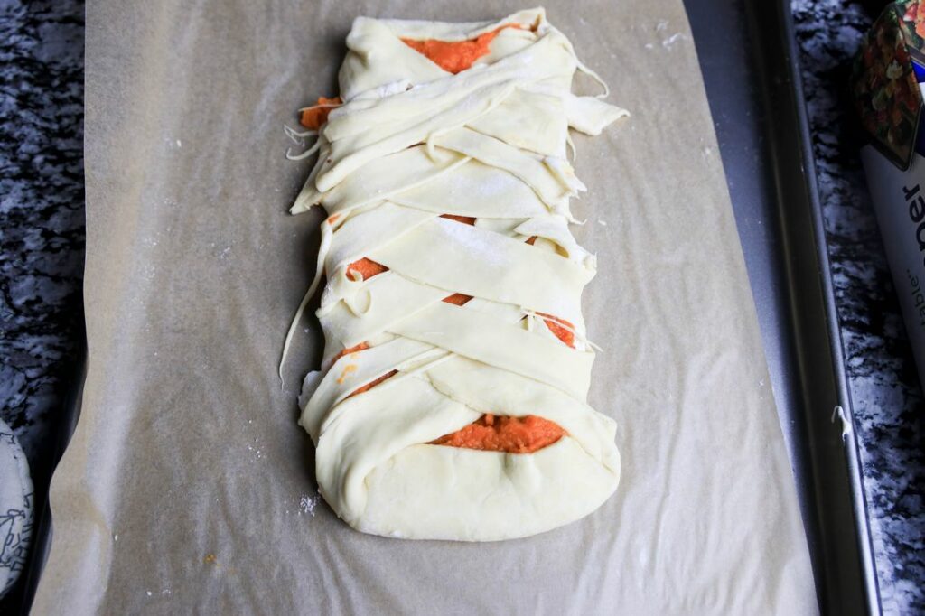 Puff pastry folded over pumpkin and cream cheese to make a braid.