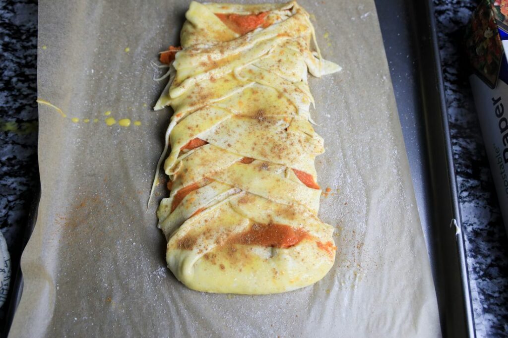 Puff pastry folded over pumpkin and cream cheese to make a braid. Brushed with egg and topped with cinnamon and sugar.