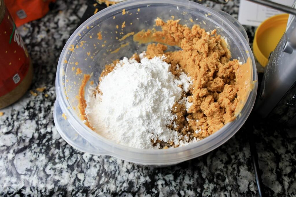 Peanut butter, cream cheese, and powdered sugar mixed together in a bowl.