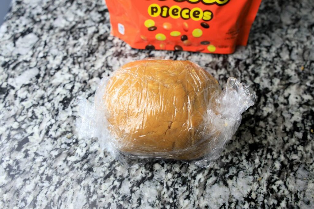 Peanut butter ball wrapped in plastic wrap.