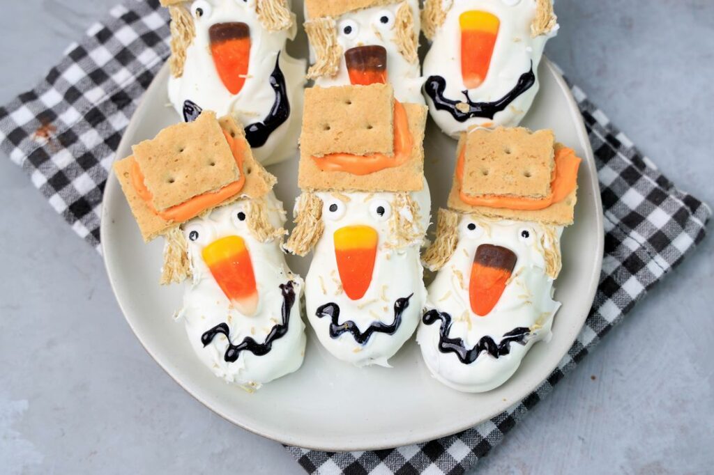 Nutter butters covered in white chocolate with candy corn nose and candy eyes.