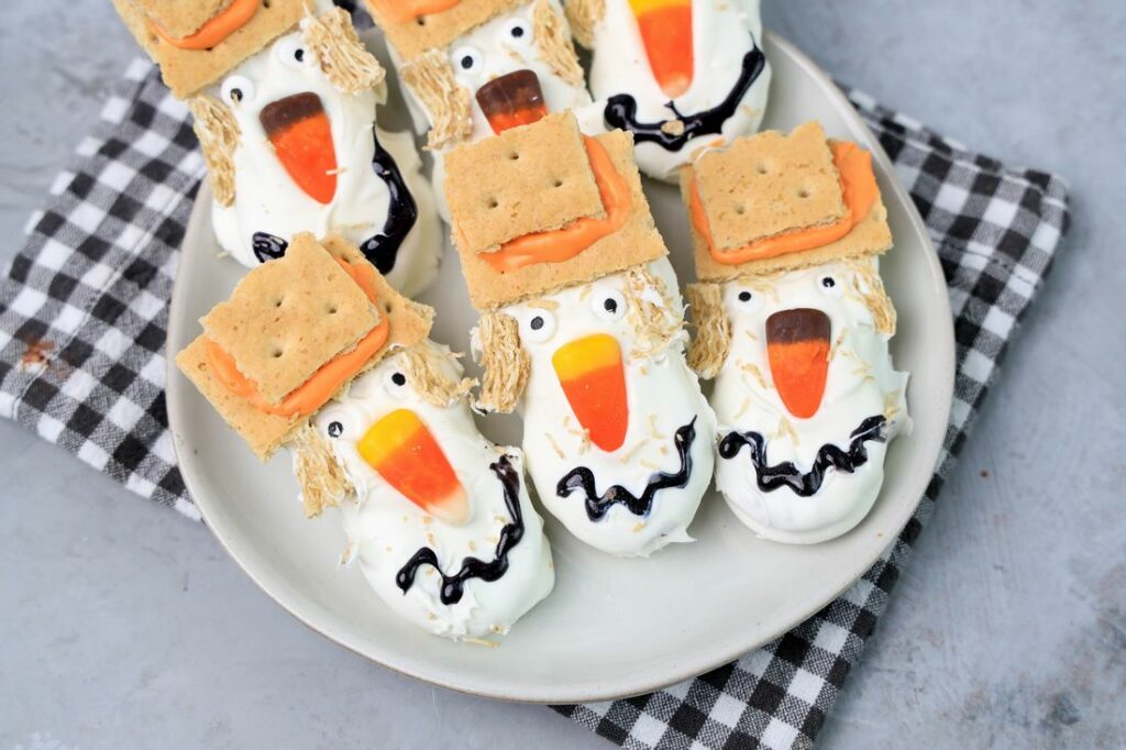 Nutter butters covered in white chocolate with candy corn nose and candy eyes.