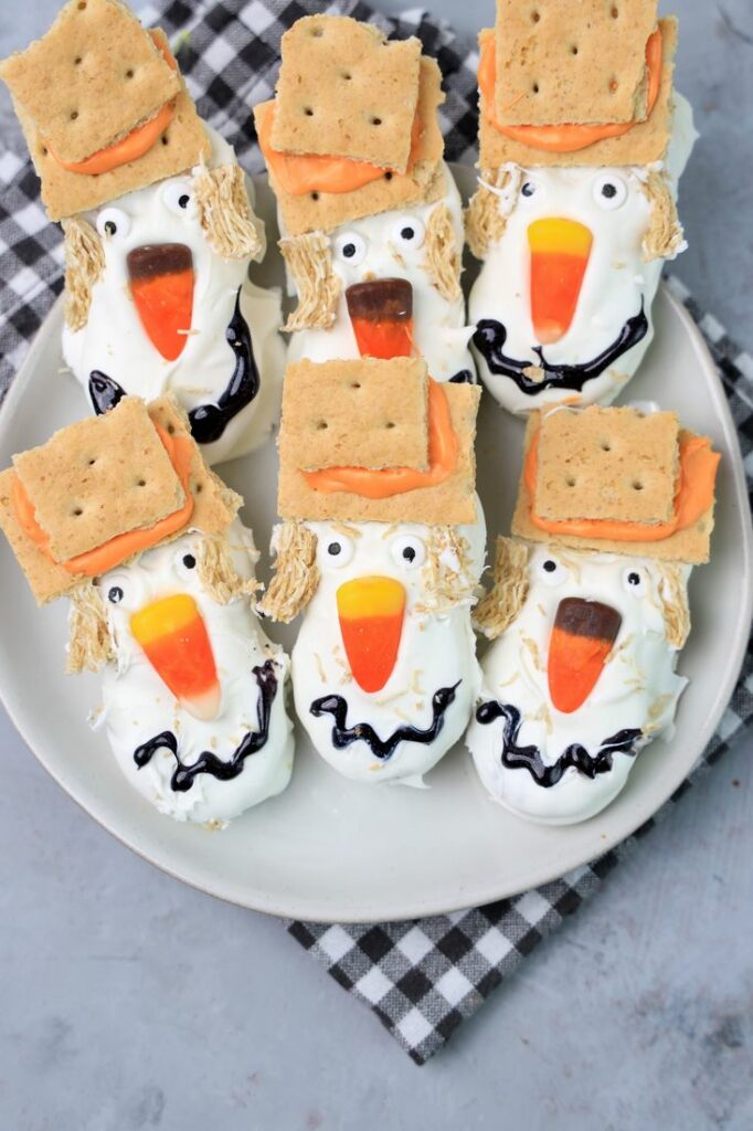 Nutter butters covered in white chocolate with candy corn nose and candy eyes.