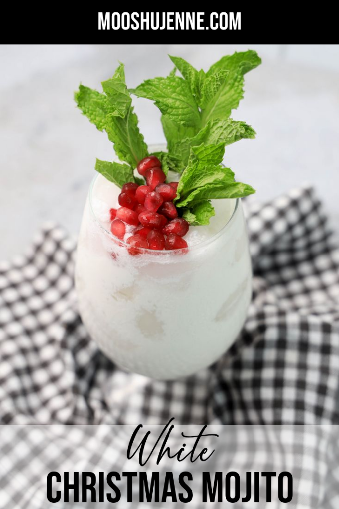 White Christmas Mojito in a glass with pomegranate and mint leaves on a gray plaid napkin.