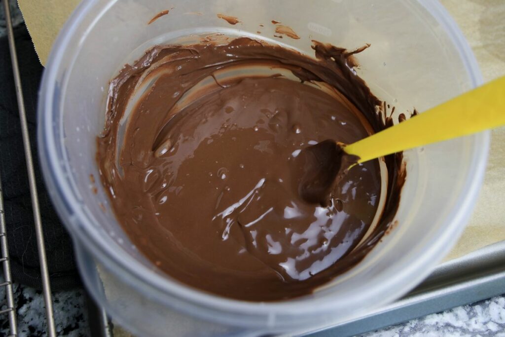 Chocolate melting wafers melted in a bowl.