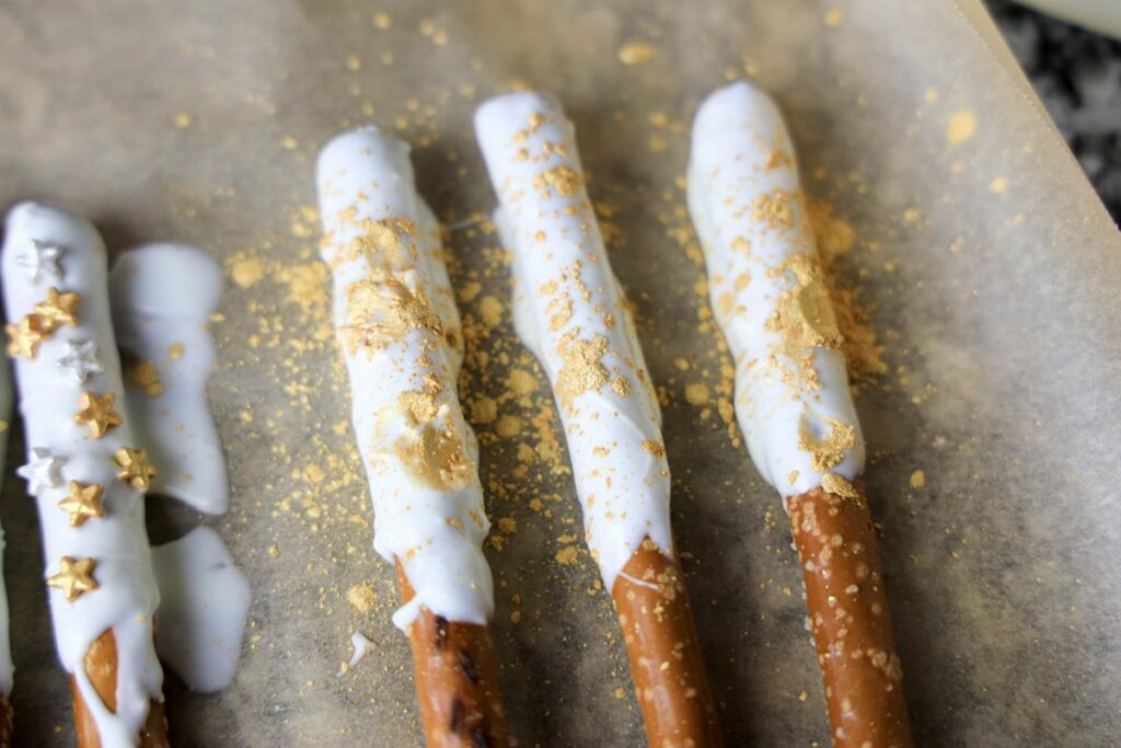 Pretzel rod with white chocolate on a piece of parchment paper.