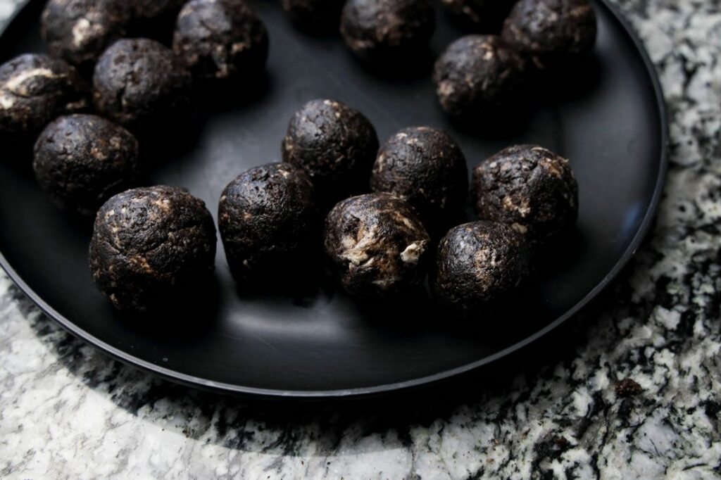 Oreo balls on a black plate before being decorated.