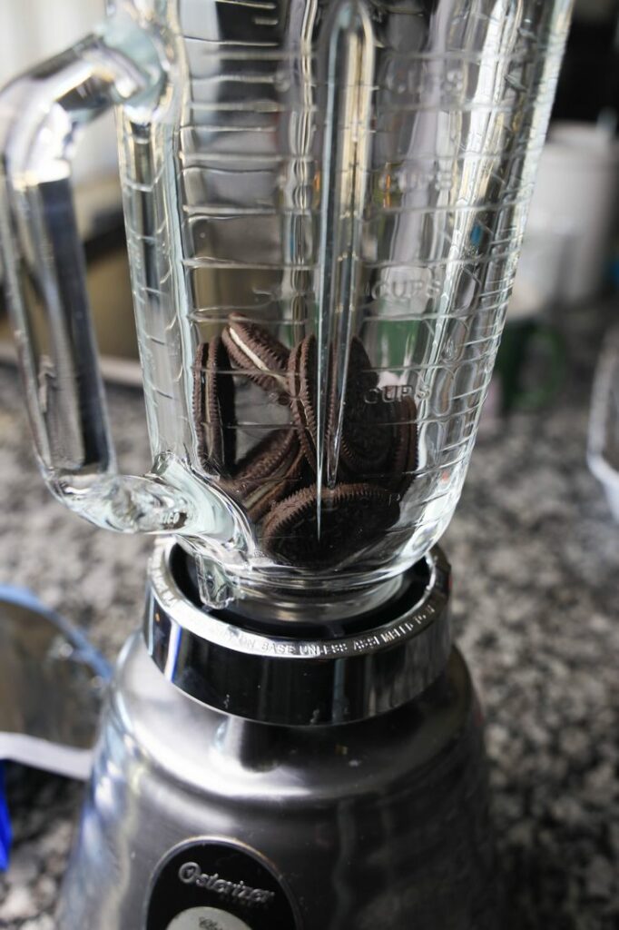 Oreo cookies in a blender on the counter top.