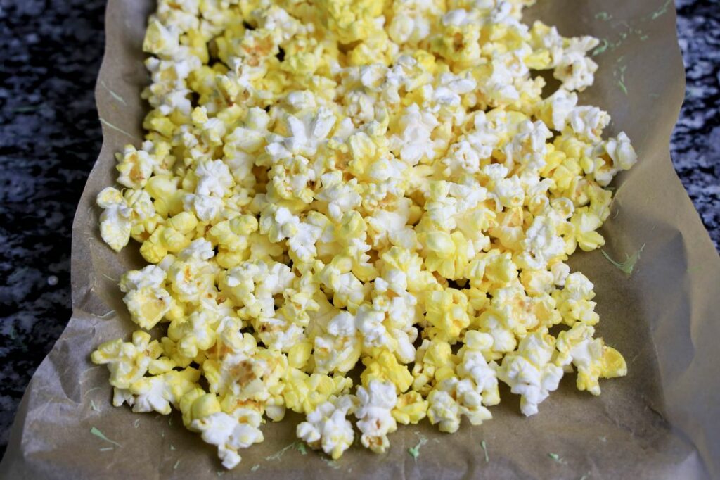 Popcorn on a baking sheet lined with parchment paper.