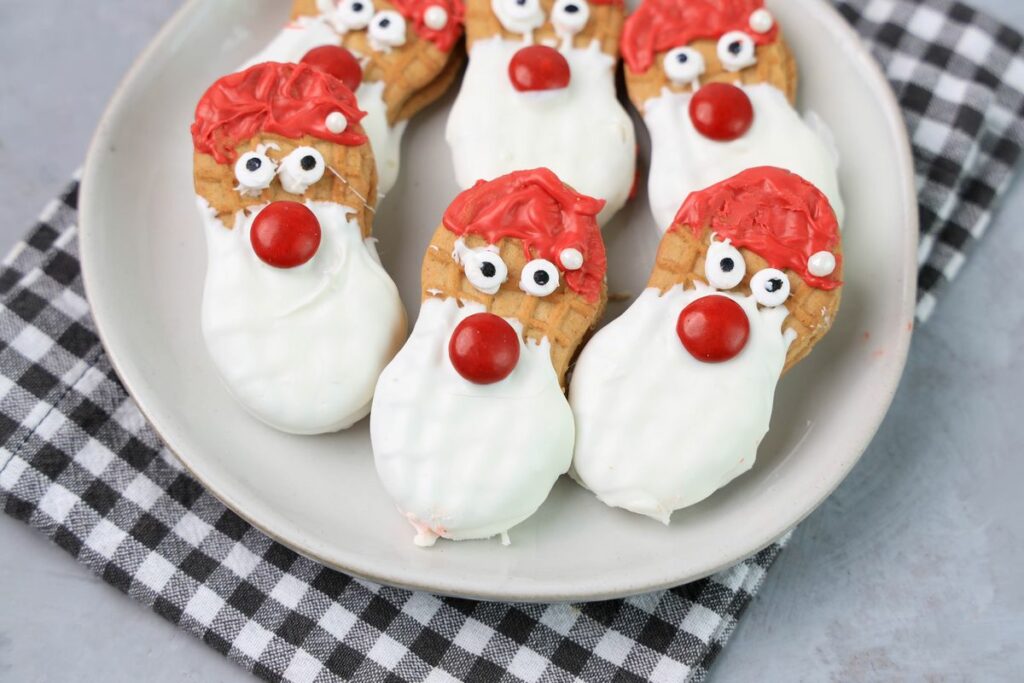 Santa nutter butters on a white plate with a gray plaid napkin.