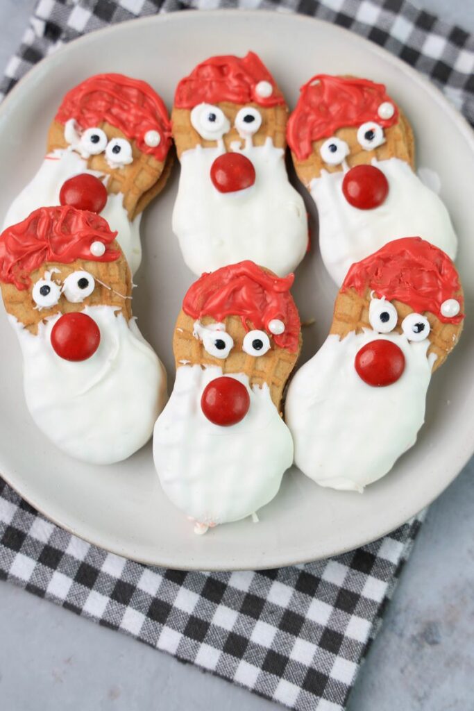 Santa nutter butters on a white plate with a gray plaid napkin.