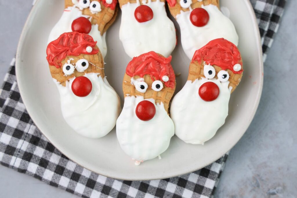 Santa nutter butters on a white plate with a gray plaid napkin.