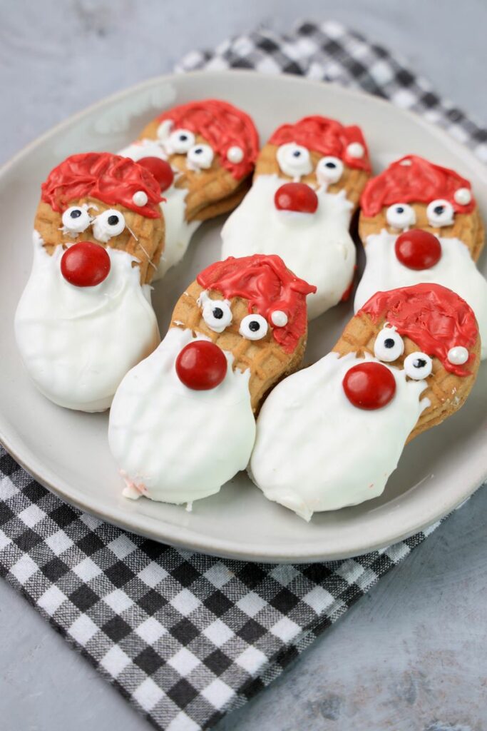 Santa nutter butters on a white plate with a gray plaid napkin.