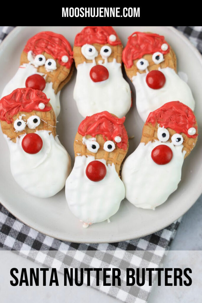 Santa Nutter Butters dipped in a white chocolate and red candy melts for a delicious Christmas snack. Serve these Santa cookies up on a holiday charcuterie board with candy canes.