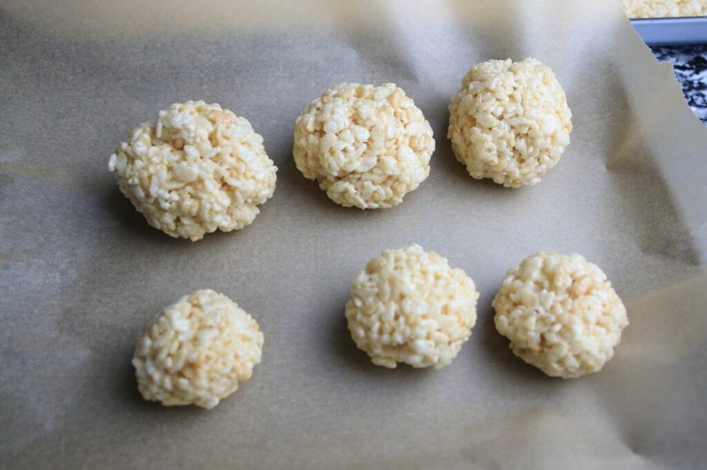 Rice krispies balls on parchment paper.