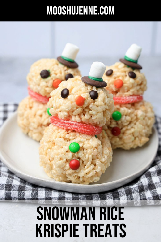 Snowman made from rice krispie treats on a white plate with a plaid napkin.