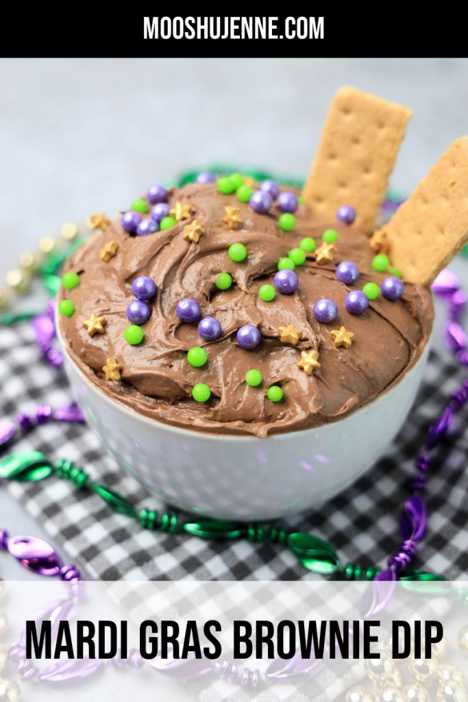 Mardi Gras Brownie Dip in a white bowl on a gray plaid napkin with mardi gras beads on a faux concrete backdrop.