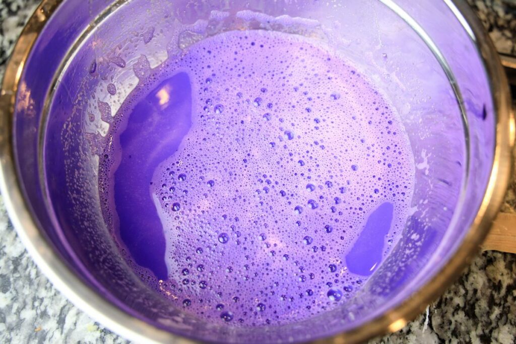 Purple jello with sweetened condensed milk in a bowl.