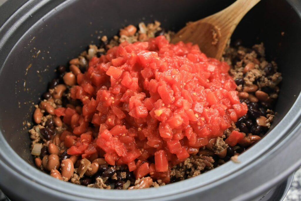 Tomatoes over the chili beans and beef mixtures in the slow cooker.