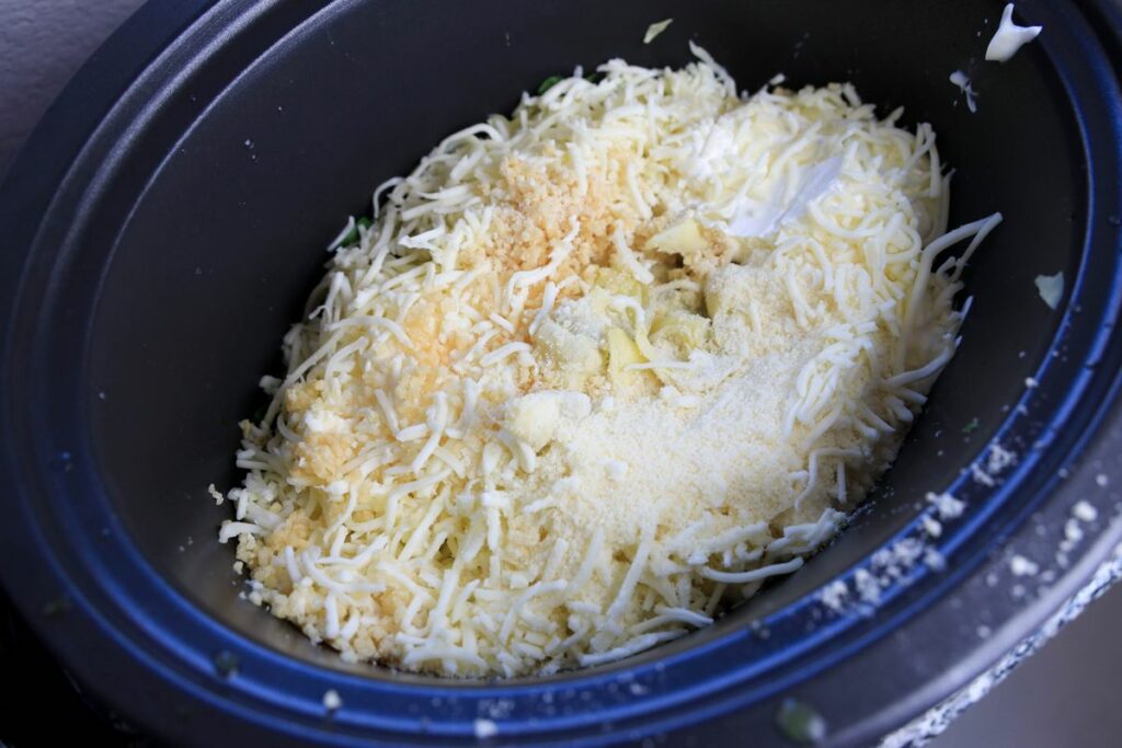Spinach, mozzarella cheese, parmesan cheese, and garlic in the slow cooker.