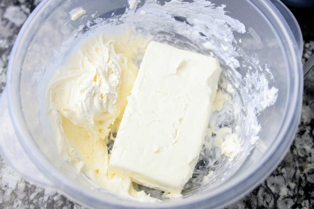 Cream cheese and whipped topping in a plastic bowl. 