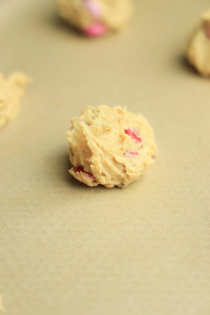 Cookie dough on parchment paper on a baking sheet.