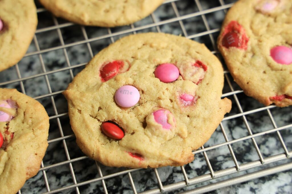 Valentine's Peanut Butter M&M cookies on a cooling rack.