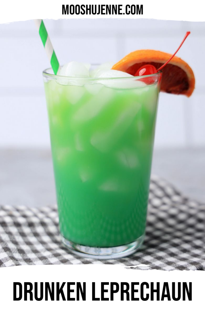 Drunken Leprechaun cocktail with a green striped straw on a gray plaid napkin with a faux concrete backdrop.