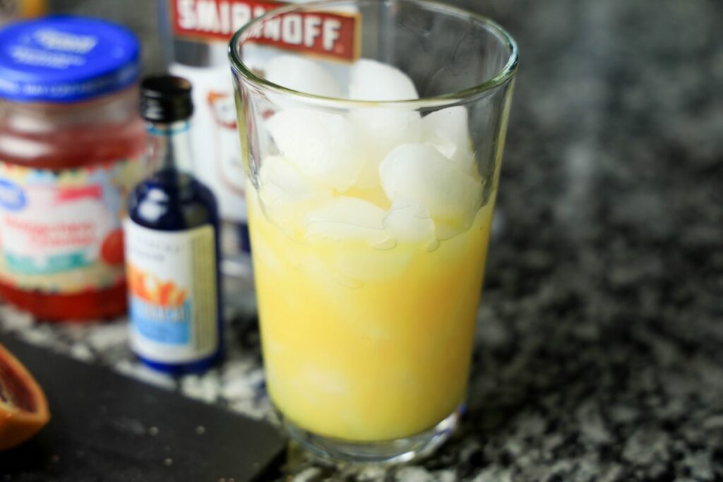 orange juice in a glass on the counter top.