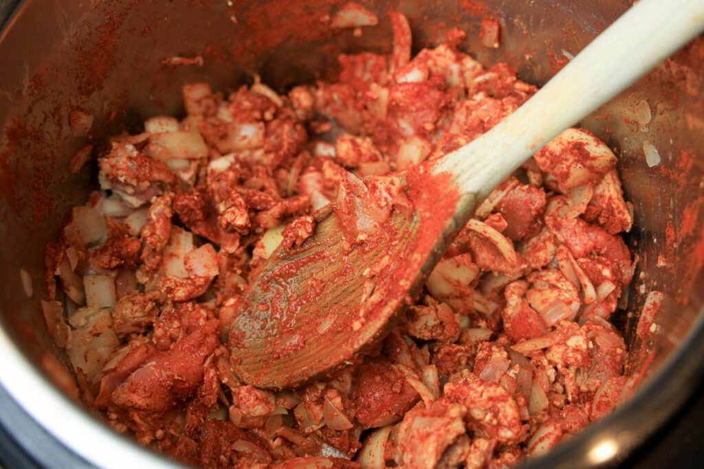 Pork stew meat covered in paprika with onions.