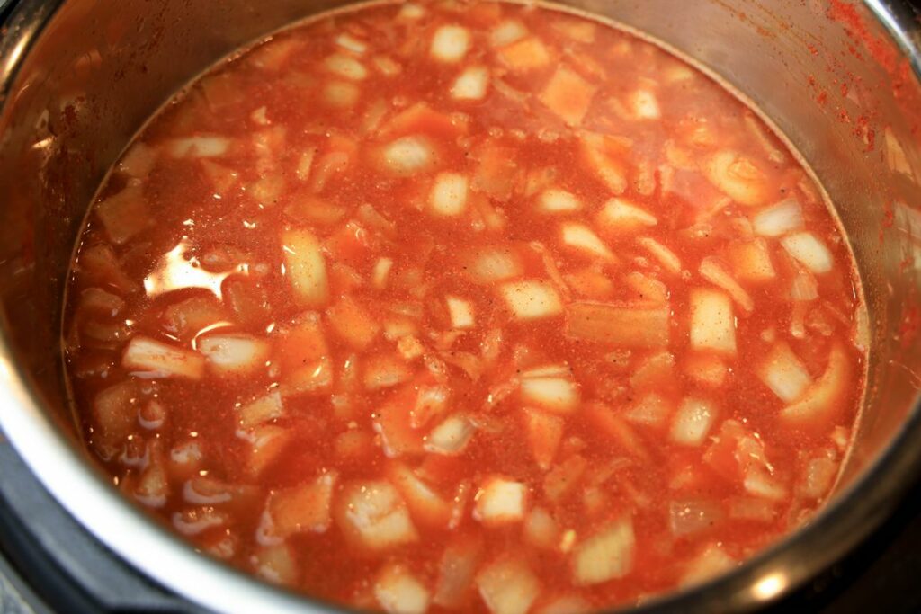 Pork, paprika, garlic, and chicken broth in the instant pot.