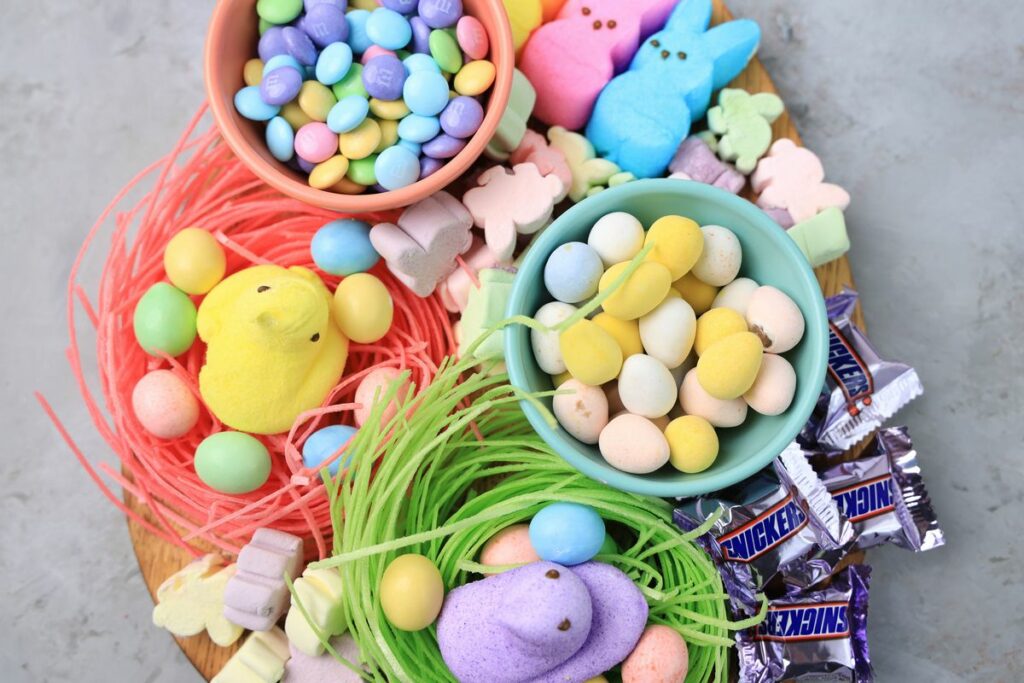 Easter Candy Charcuterie Board with peeps candy, cadbury eggs, and m&m's on an egg shaped board.