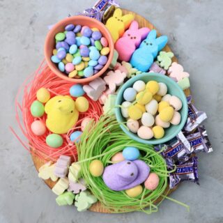 Easter Candy Charcuterie Board with peeps candy, cadbury eggs, and m&m's on an egg shaped board.