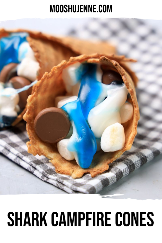 Shark campfire cones are loaded with marshmallows, Hershey's kisses, and shark gummy candies in a waffle cone. Easy to make on the grill or in the oven for a fun summer treat. Perfect for Shark Week or Jaws movie parties.