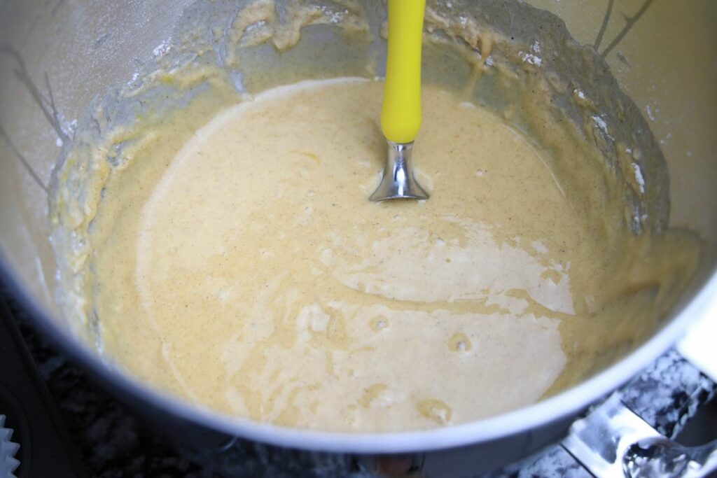 Batter for Apple Cider Muffins in a stainless steel mixing bowl.