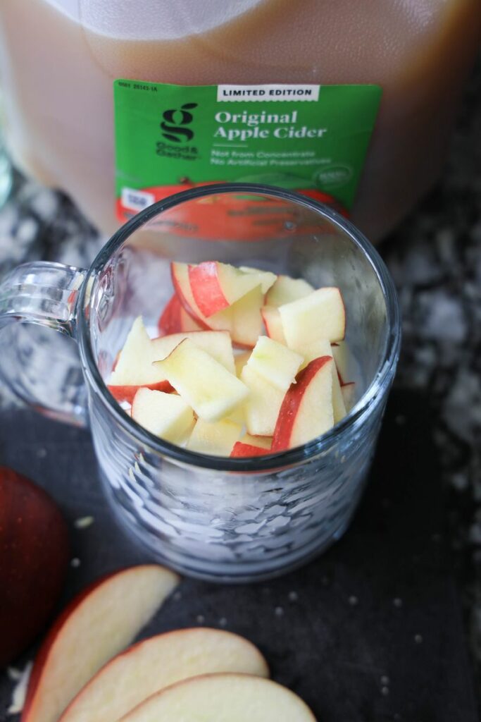 Apple pieces in a shirt cocktail glass on the counter.