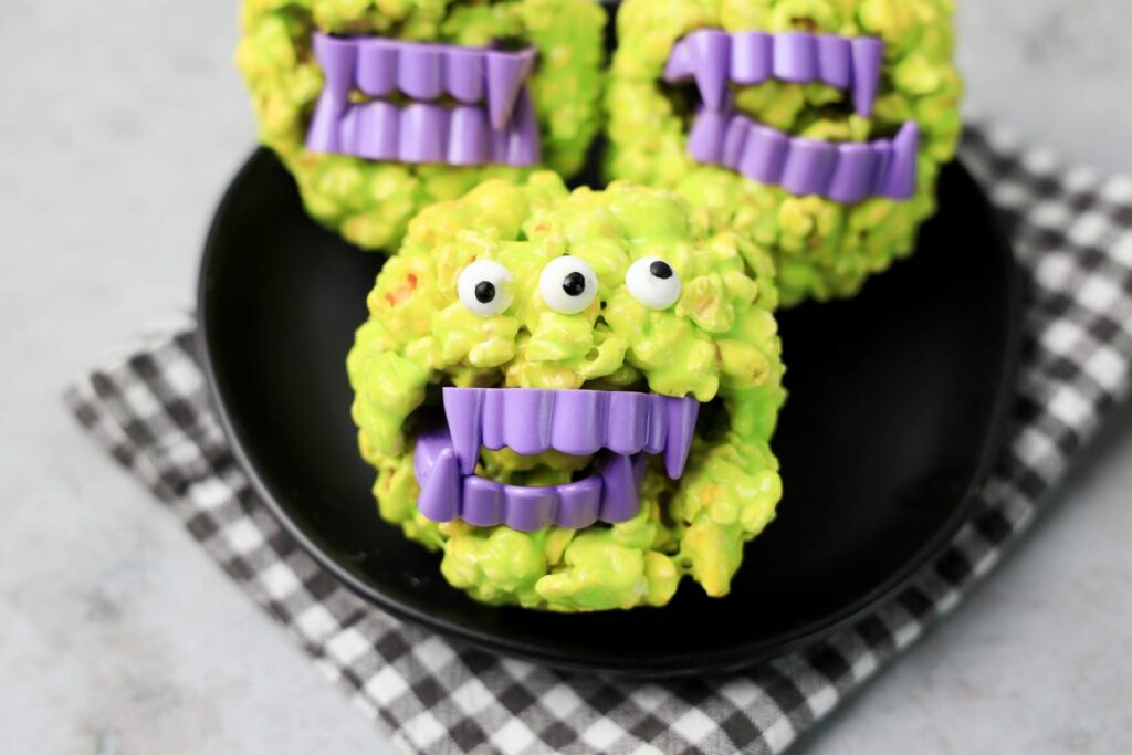 Monster Popcorn Balls with candy eyes and purple vampire teeth. 