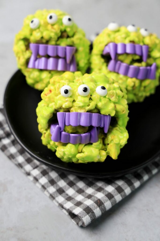 Monster Popcorn Balls with candy eyes and purple vampire teeth.