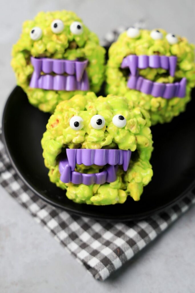 Monster Popcorn Balls with candy eyes and purple vampire teeth.