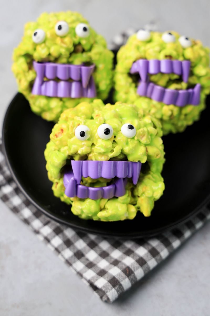 Monster Popcorn Balls with candy eyes and purple vampire teeth.
