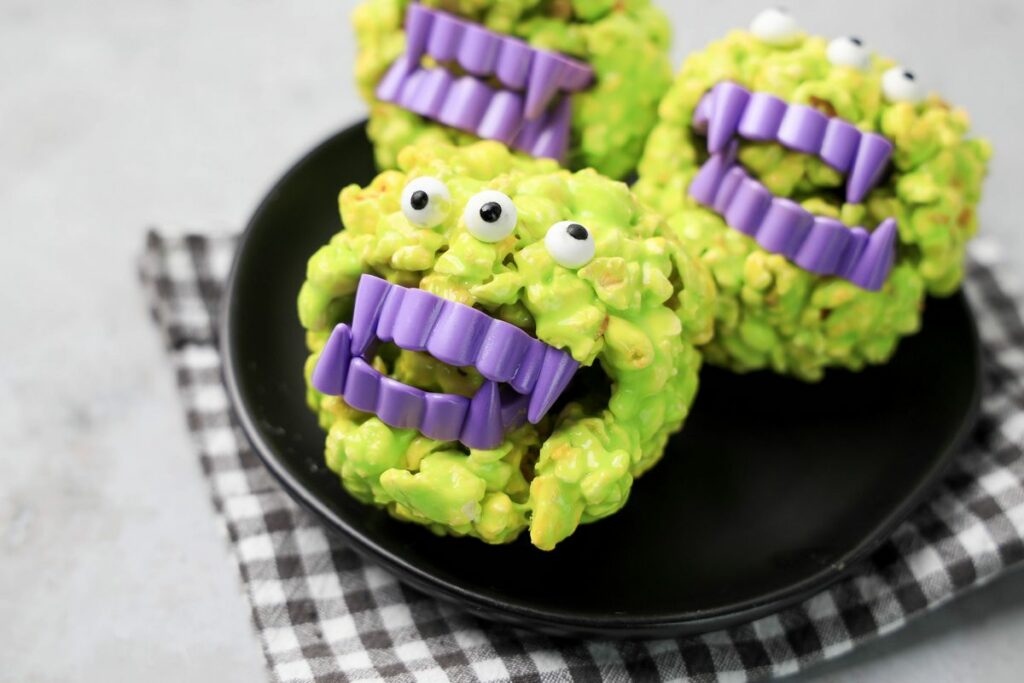 Monster Popcorn Balls with candy eyes and purple vampire teeth.